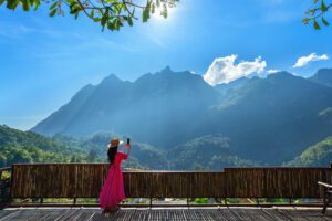 Woman in a red sari looking out at the Himalaya from a hill viewpoint