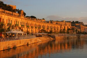 Udaipur City Palace lit by the evening sun along the shore of Lake Pichola