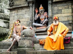 Sadhus in saffron robes at a temple doorway in Kathmandu, Nepal