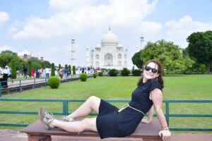 Young female traveler posing in front of the Taj Mahal in Agra, India during her Golden Triangle tour
