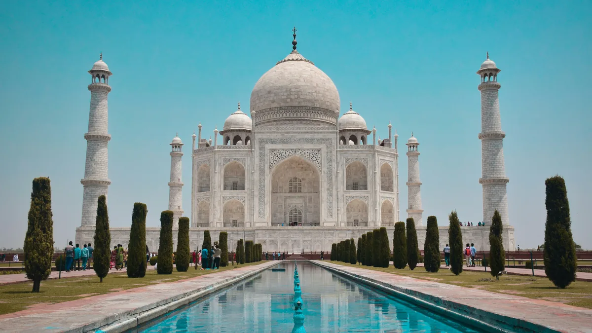 Golden triangle tour: the Taj Mahal at sunrise reflected in the long pool of the Mughal garden, Agra