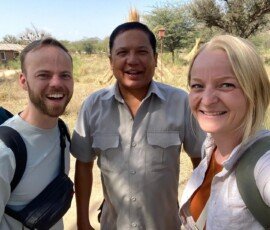 Unforgettable moments with our trusted local guide in rural India. Happy young couple taking selfie with their local Indian guide during village tour in Rajasthan