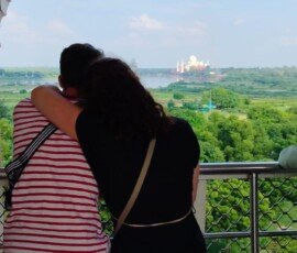 A breathtaking view of the Taj Mahal from the historic Agra Fort—a moment our travelers will never forget. Travelers viewing the Taj Mahal in the distance through Mughal arch at Agra Fort, India