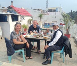 Our travelers savoring authentic Indian cuisine with their guide at a charming rooftop restaurant. Tourists with local guide enjoying authentic Indian thali meal at a rooftop restaurant in India