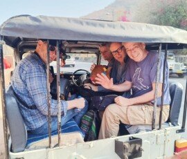 Our travelers exploring Rajasthan in style aboard a classic open jeep. Group of tourists enjoying an open jeep ride during their Rajasthan India tour