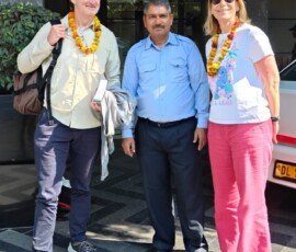 A warm traditional welcome with marigold garlands marks the start of our travelers' India journey. Couple receiving traditional marigold garland welcome from driver upon arrival at Delhi hotel India