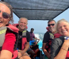 Our travelers enjoying a thrilling speedboat ride along the Indian coast. Happy tourists in life jackets enjoying a speedboat ride during their India coastal tour